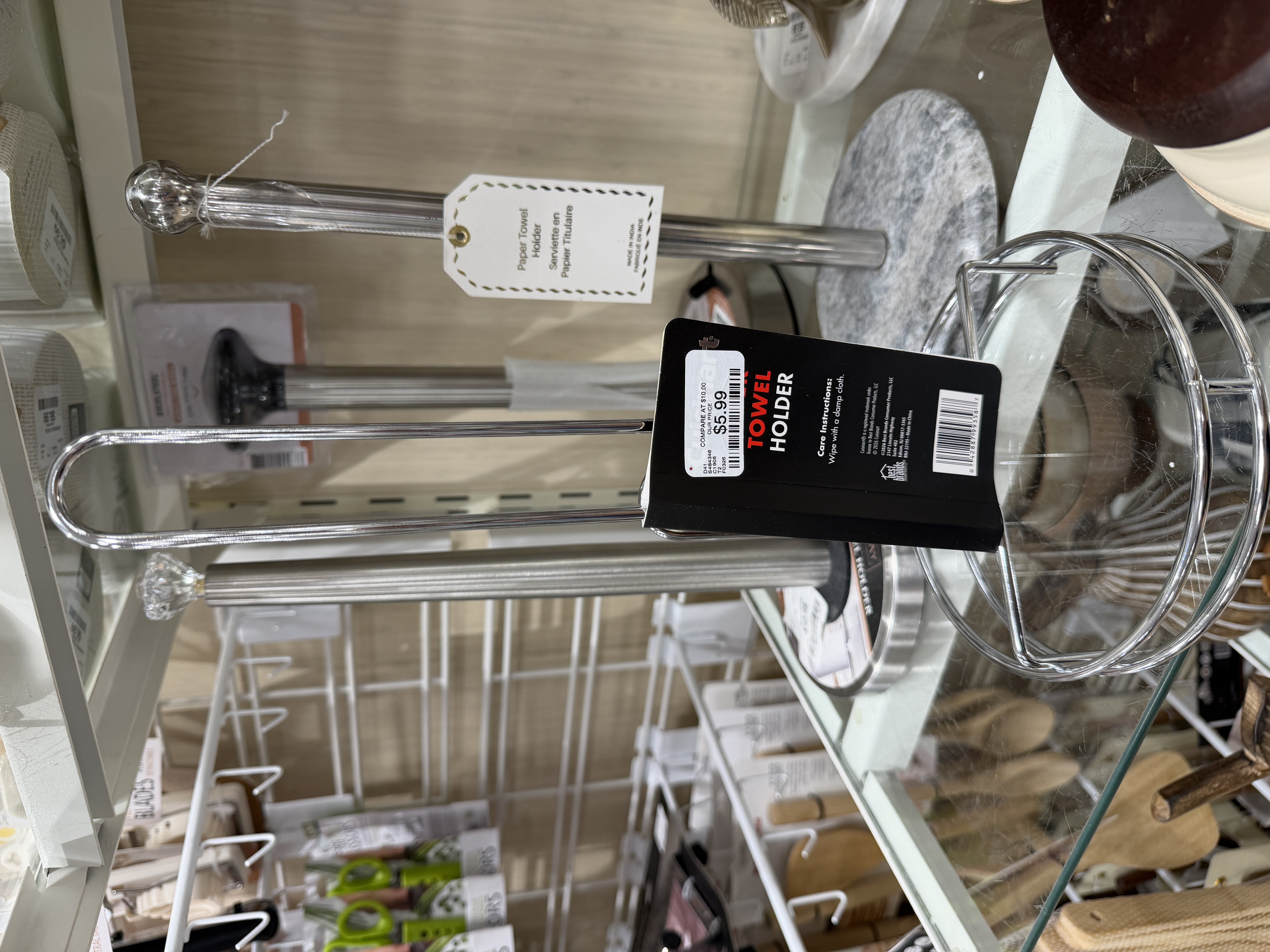 Metal towel holder accessory with a price tag in a home goods aisle